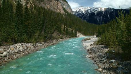 Serene Turquoise River Amidst Majestic Mountains wallpaper
