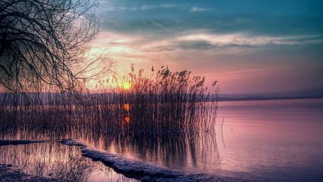 Serene Purple Sunset Over Tranquil Lake wallpaper
