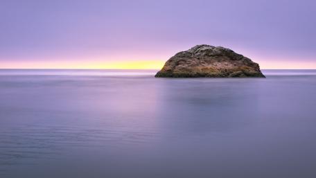 Serene Islet at Dusk Over Calm Waters wallpaper