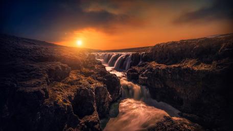 Serene Sunset Over Cascading Waterfall wallpaper