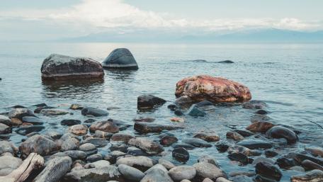 Serene Shoreline with Tranquil Waters and Rocks wallpaper