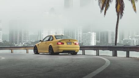 Vibrant Yellow BMW Under a Misty Skyline wallpaper