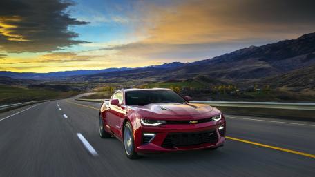 Powerful Chevrolet Camaro on Scenic Highway at Sunset wallpaper