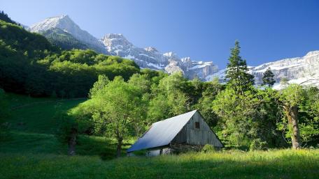 Serene Cottage Amidst Majestic Alps wallpaper