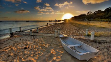White boat on a sendy beach wallpaper