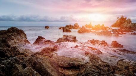 Tranquil Sunset Over the Rocky Lagoon Shoreline wallpaper