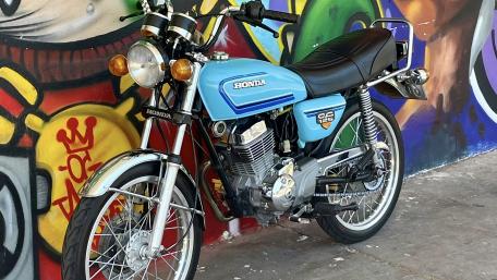 Classic Honda Motorcycle Against Vibrant Street Art Background wallpaper