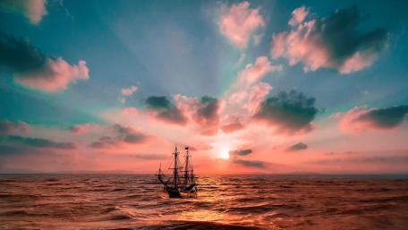 Ethereal Sunset Over a Sailing Ship wallpaper