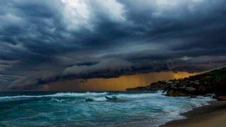 Dramatic Storm Clouds Over Serene Beach Scene wallpaper