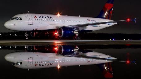 Delta Airplane at Night with Reflective Surface wallpaper