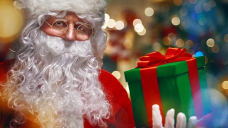 Joyful Santa Claus with Gift for Christmas Celebration wallpaper