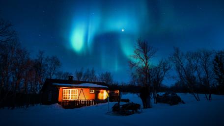 Arctic Glow Over Cozy Cabin wallpaper