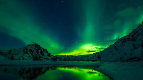 Enchanting Aurora Borealis Over Snowy Mountains wallpaper