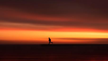 Running Towards the Horizon Under a Fiery Sunset wallpaper