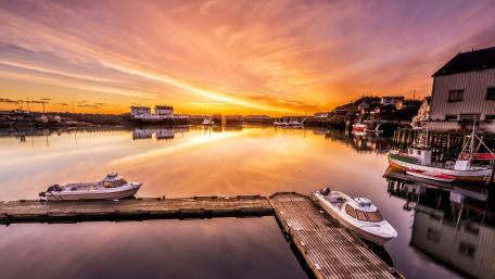 Serene Sunset Over a Quiet Pier and Boats wallpaper