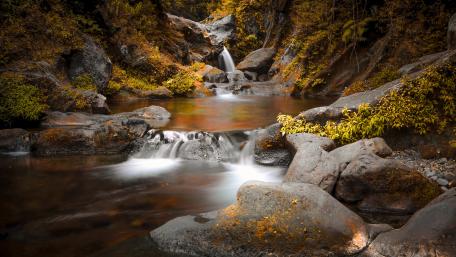Tranquil Waterfall Amidst Rocky Serenity wallpaper