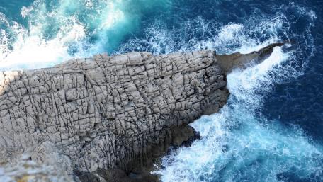 Serene Cliffside Waves and Rocky Shores wallpaper
