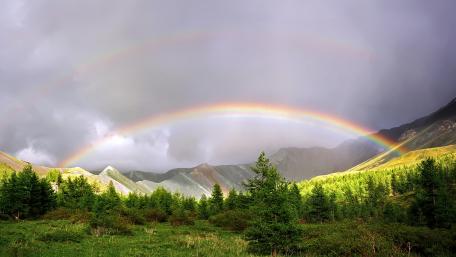 Majestic Rainbow Over Serene Mountains wallpaper