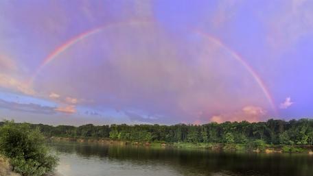 Vibrant Rainbow Over Serene River Landscape wallpaper