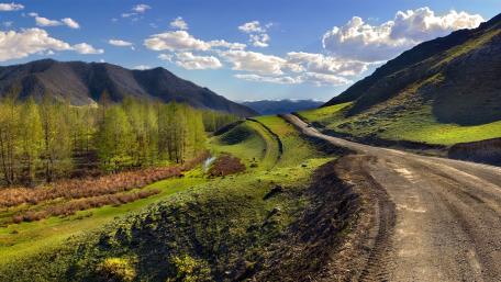 Majestic Mountain Roadway Amidst Lush Landscape wallpaper