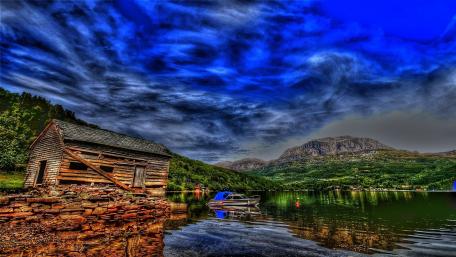 Serene Lake View with Rustic Hut and Motorboat wallpaper