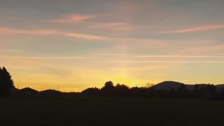 Serene Sunset Over Mountains and Fields wallpaper
