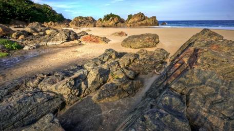 Serene Coastal Landscape of Rocks and Sand wallpaper
