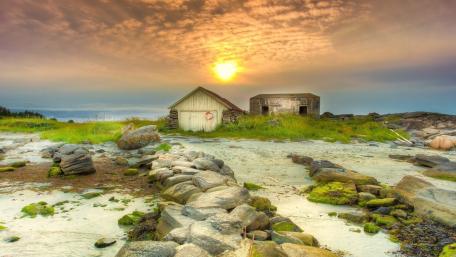 Serene Coastal Sunset Over Rustic Huts wallpaper