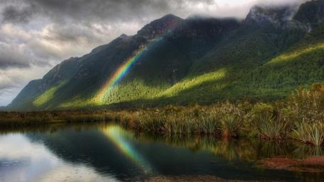 Majestic Rainbow Over Tranquil River Scene wallpaper