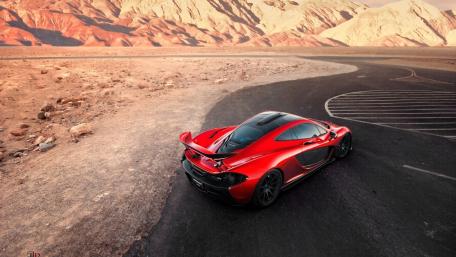 Fiery McLaren Racing Through Desert Landscape wallpaper