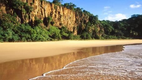 Tranquil Beach Retreat Amidst Majestic Cliffs wallpaper