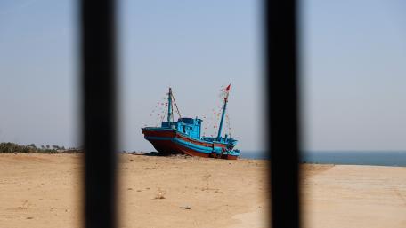 Serenity by the Coastline with a Colorful Boat wallpaper