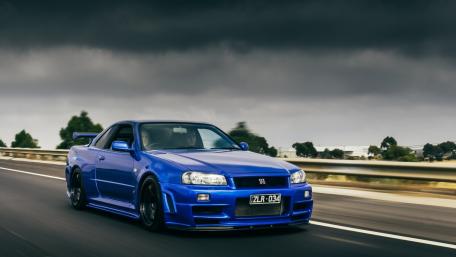 Speeding Blue Nissan GT-R Under Moody Skies wallpaper