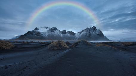 Majestic Mountains Under a Vibrant Rainbow wallpaper