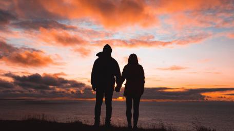 Couple Embracing at Sunset on the Coast wallpaper