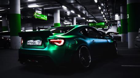 Sleek Green Sports Car in Urban Parking Garage wallpaper