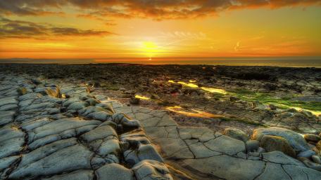 Tranquil Sunset Over Rocky Coastline wallpaper