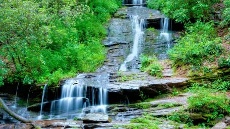 Serene Waterfall Amidst Lush Greenery wallpaper