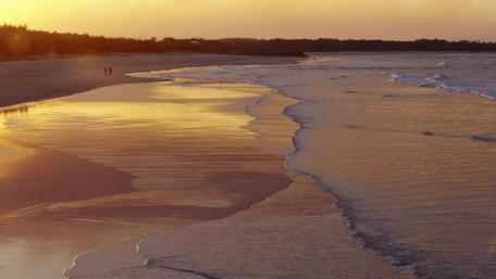 Serene Sunset Over Tranquil Beach Waves wallpaper