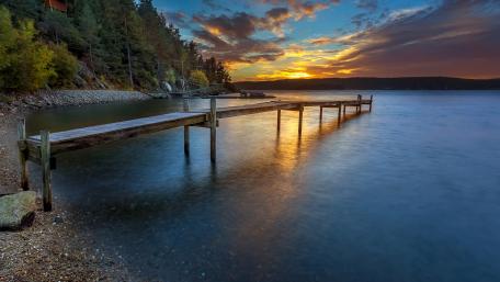 Serene Sunset Over Tranquil Lake Pier wallpaper