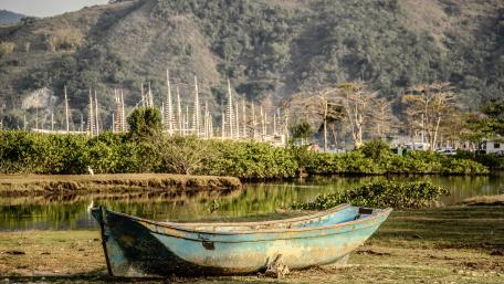 Serene Mountain Lake with a Rustic Boat wallpaper