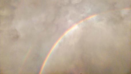 Enchanting Rainbow Under Cloudy Skies wallpaper