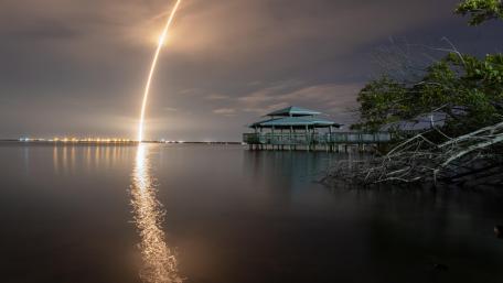 Rocket Launch Reflection Over Serene Waters at Night wallpaper