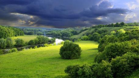 Serene River Landscape Under Dramatic Skies wallpaper