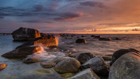 Serene Sunset Over Rocky Shoreline wallpaper