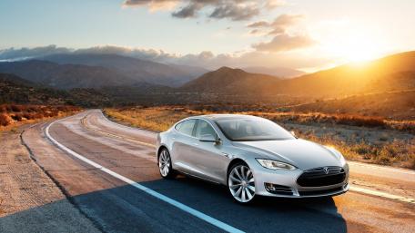 Sleek Tesla on the Open Road at Sunset wallpaper