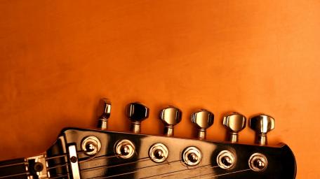 Vibrant Guitar on Warm Yellow Background wallpaper