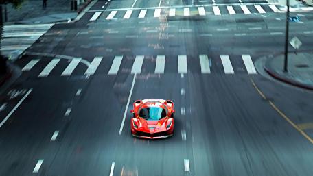 Sleek Ferrari Racing Down the Street wallpaper