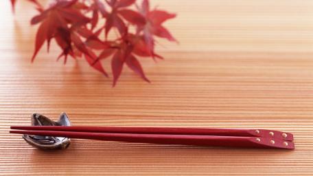 Elegant Red Chopsticks on Wooden Surface wallpaper