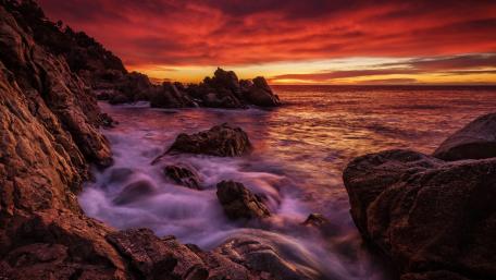 Fiery Sunset Over Rugged Coastline wallpaper